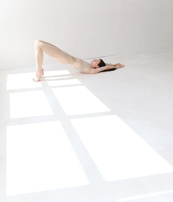 Woman in a calm yoga pose in a bright, serene studio.